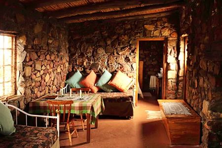 Where It All Began - Blog - Leave the city behind: 3 secluded mountain getaways near Cape Town - Inside of Goatherder House with Sitting Area and Small Kitchen Table