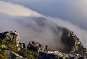 Where It All Began - Adventure Hiking in Cape Town, Kruger & Victoria Falls - Cape Town - Parker Cottage - Lady Sitting on Misty Mountain Peak