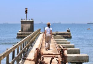 Where It All Began - Namibia & Okavango Overlanding 4x4 Adventure - Walvis Bay - Woman Walking on Pier