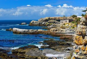 Where It All Began - Whale Coast Walking Adventure - Exploring Hermanus - Shot of Coastal Sea View and Stone House