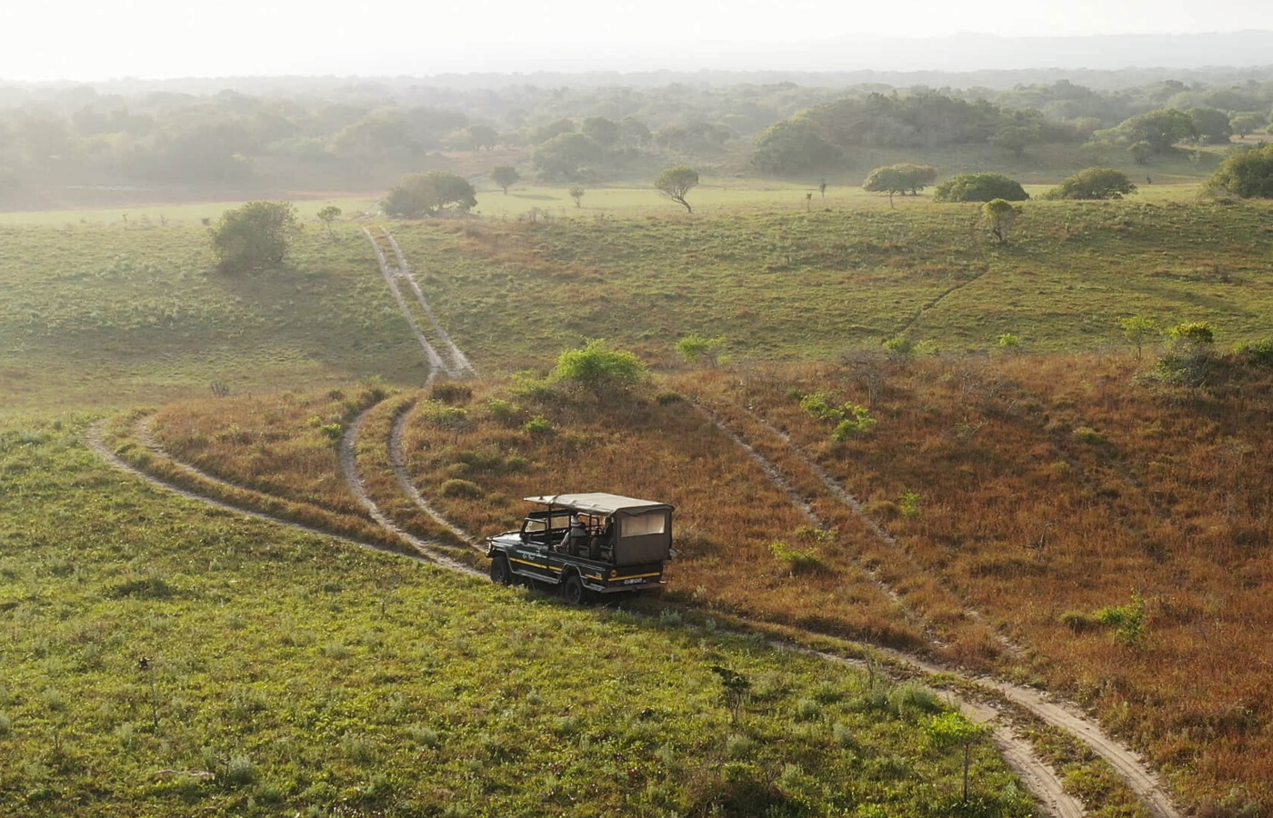 S050 - IT3 - Safari Car Travelling on Dirt Road Where It All Began - Journeys - Tropical African Lake and Forrest Slackpacking Adventure - Safari Car Travelling on Dirt Road
