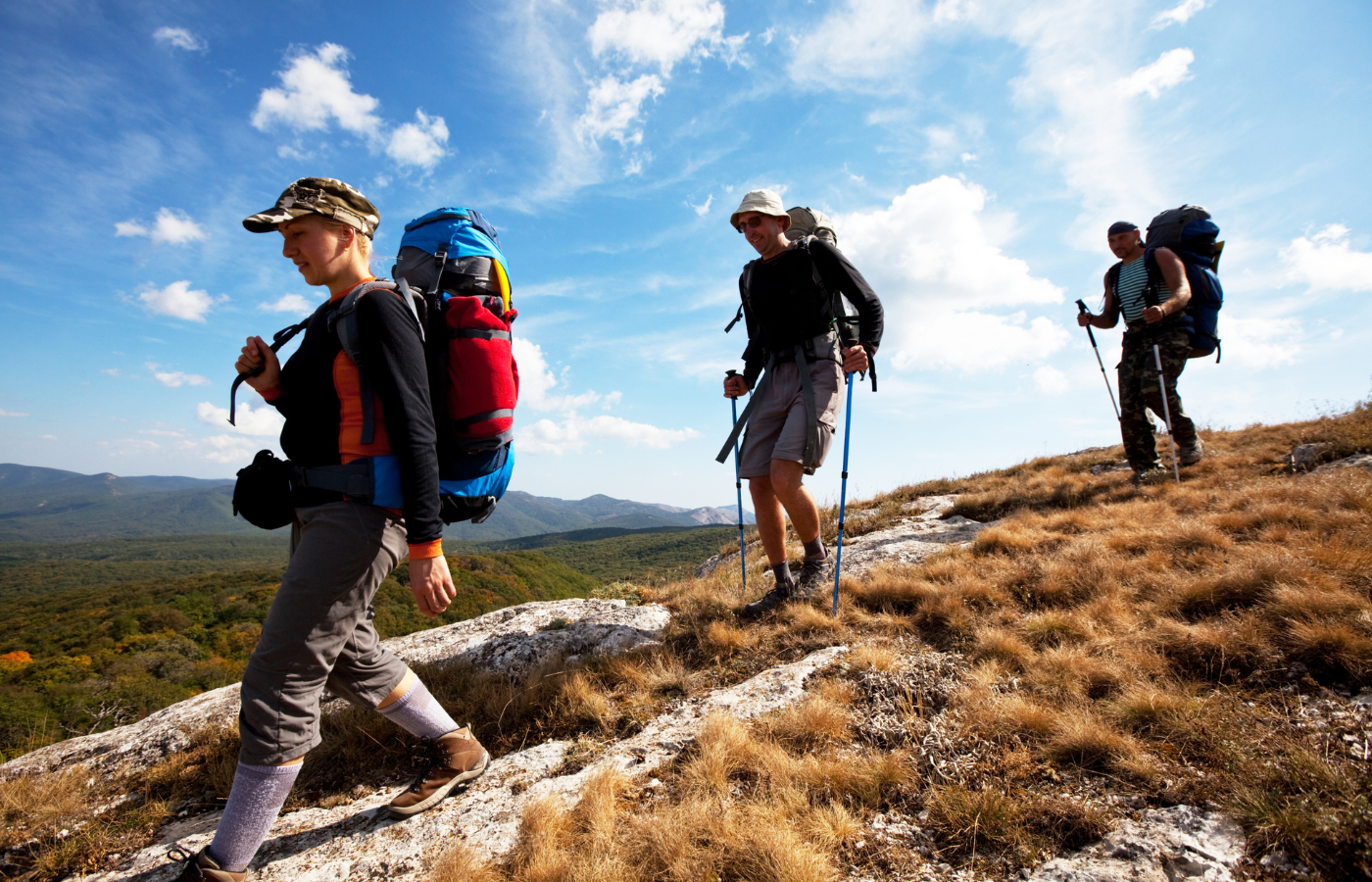 S052 - IT4 - Three Hikers Heading Down the Mountain with Hiking Gear and Hiking Poles Where It All Began - Journeys - Wild Coast Hotel Hopper - Three Hikers Heading Down the Mountain with Hiking Gear and Hiking Poles