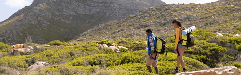 Where It All Began - Blog - Hiking Trails - Fit Afrcan American Couple Wearing Backpacks Hiking on the Coast